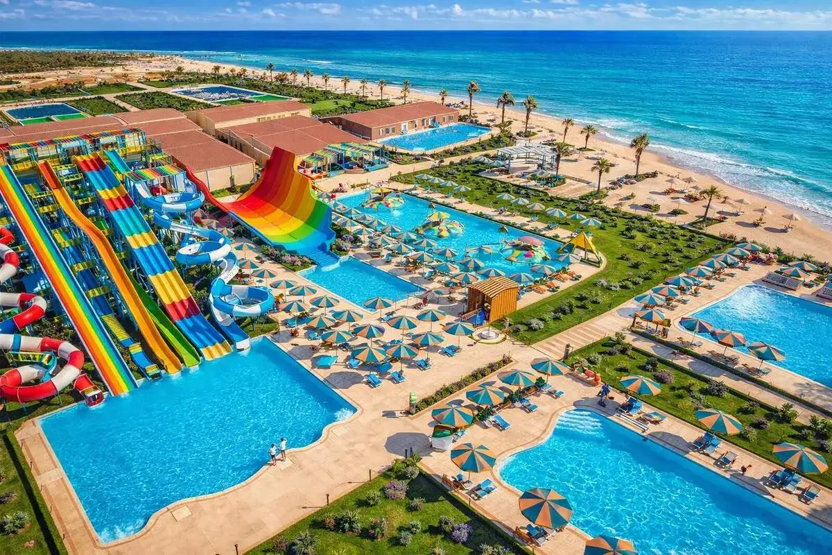 Rajski hawajski aqua park resort z kolorowymi zjeżdżalniami, basenami i plażą.