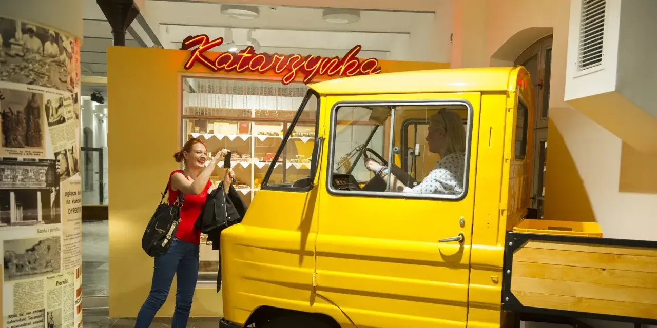 Kobieta robi zdjęcie żółtej ciężarówki 