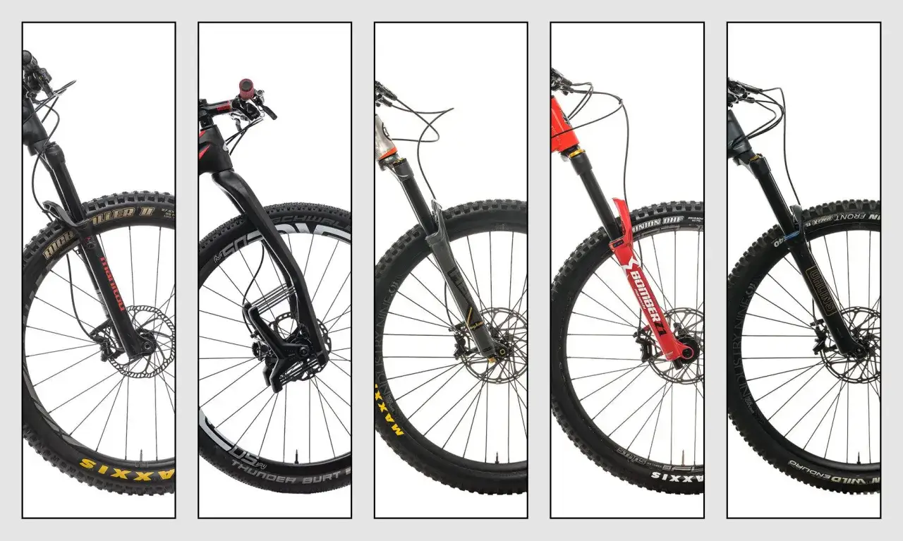 Five mountain bike forks are displayed, showcasing a comparison of brands like RockShox vs Fox, Manitou, Marzocchi, and Öhlins.