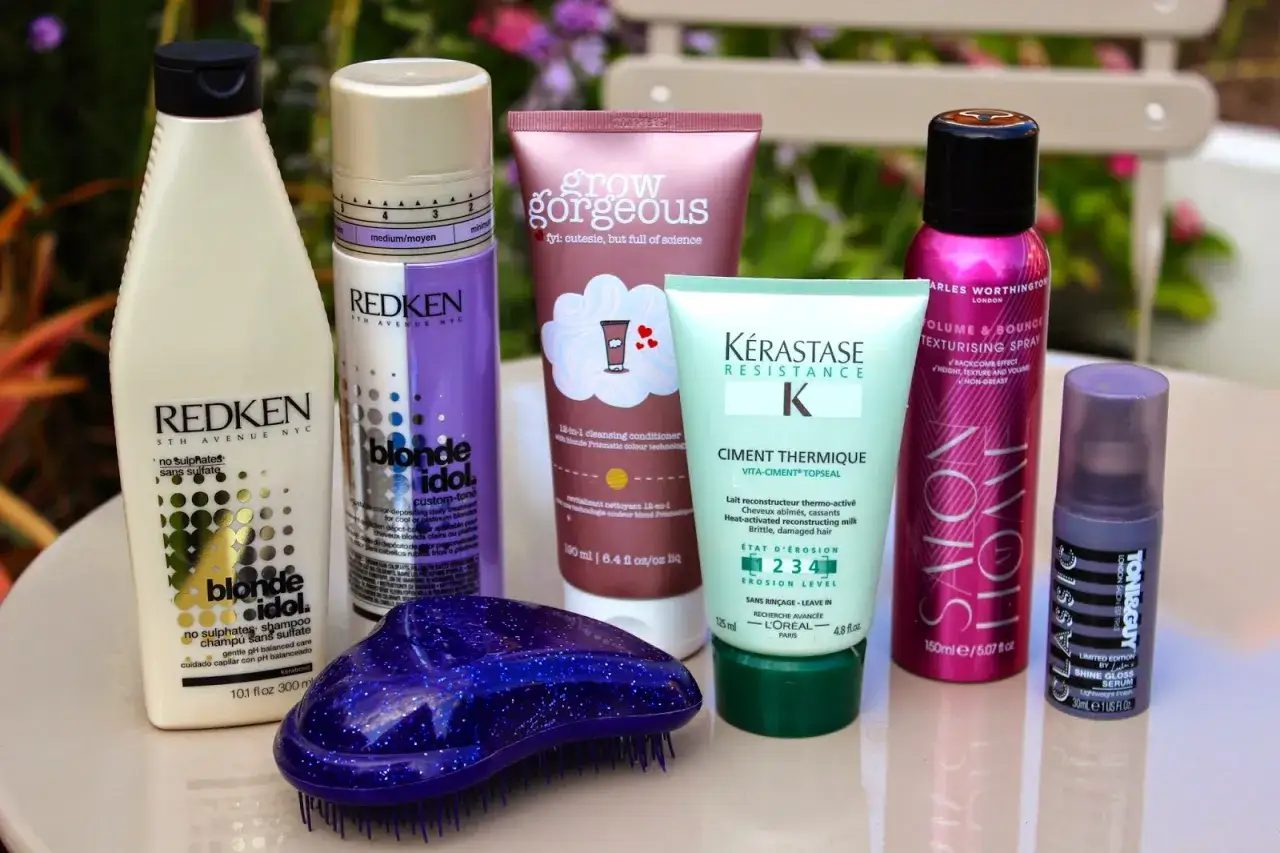 Routine de soins cheveux d&eacute;color&eacute;s maison : shampoing, soin, spray texturisant, s&eacute;rum.
