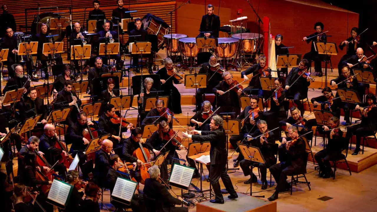 Ein Orchester spielt dramatische Musik. Klassiker erklingen, während die Musiker mit Leidenschaft ihre Instrumente führen.