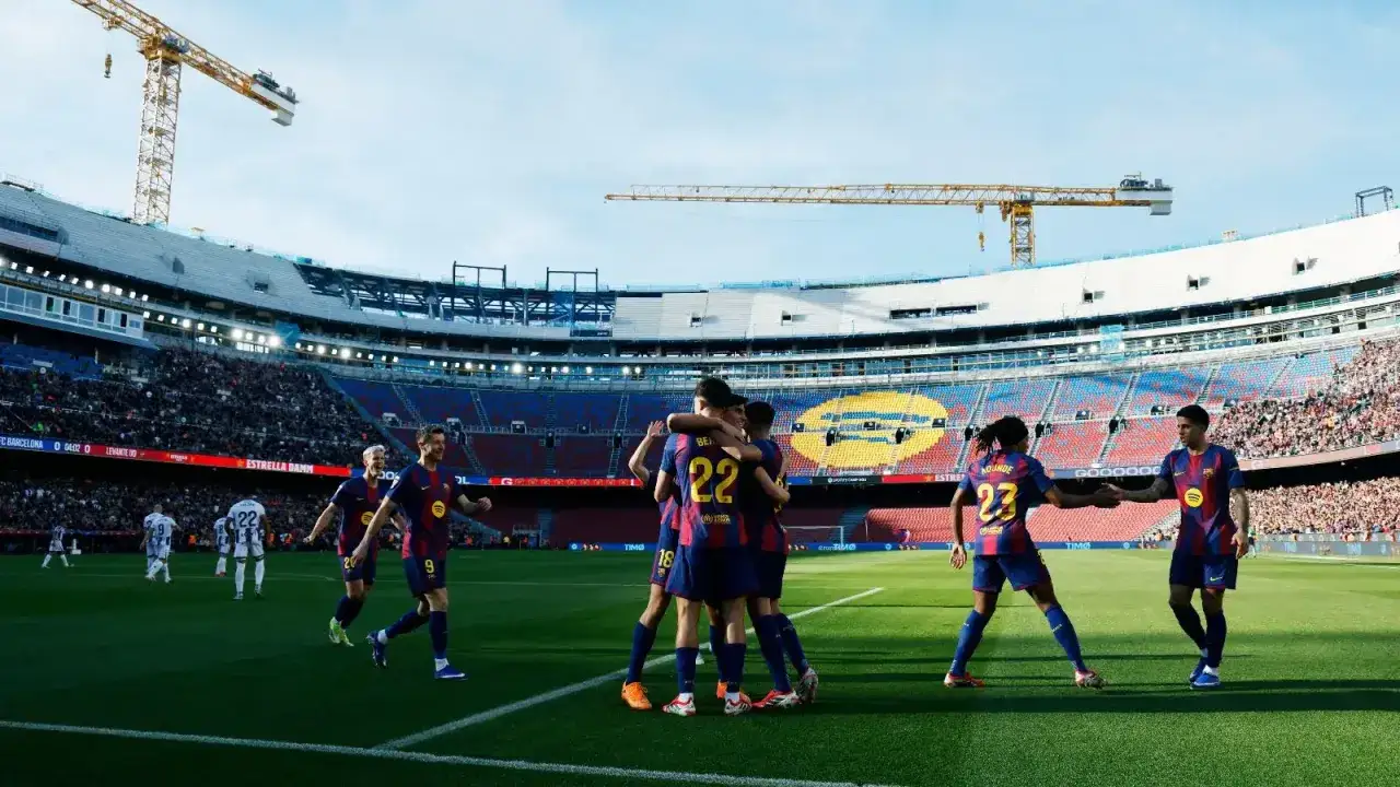 Piłkarze FC Barcelona świętują bramkę przeciwko Levante. Stadion Camp Nou, tłumy kibic&oacute;w i dźwigi w tle.