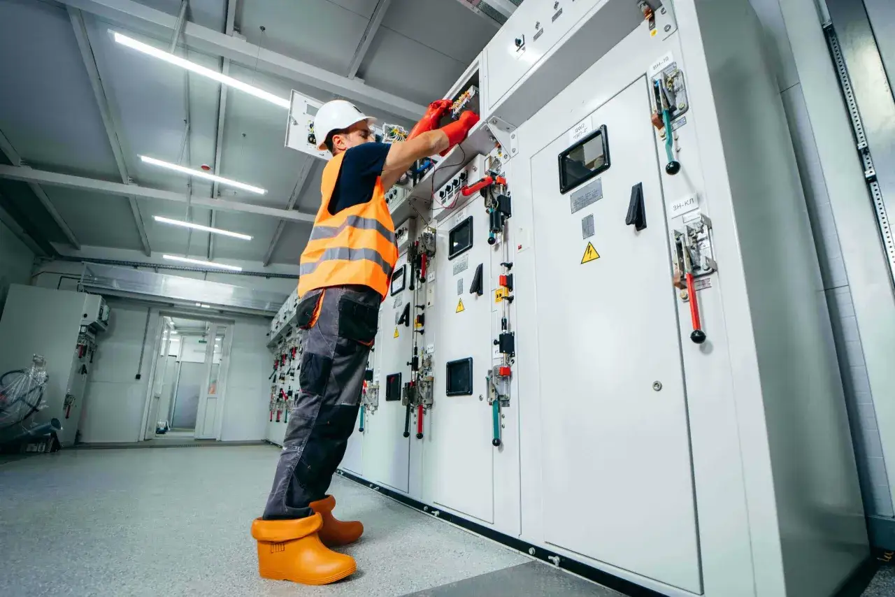 Elektriker arbetar med en kontrollpanel, f&ouml;ljer ensamarbete regler.
