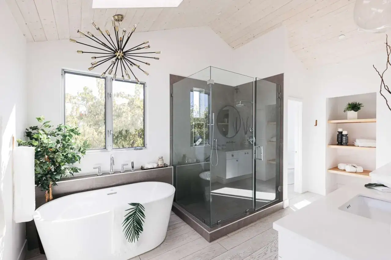 Bagno moderno con vasca freestanding, doccia in cristallo e piante. Un vero mini spa in casa per rilassarsi.