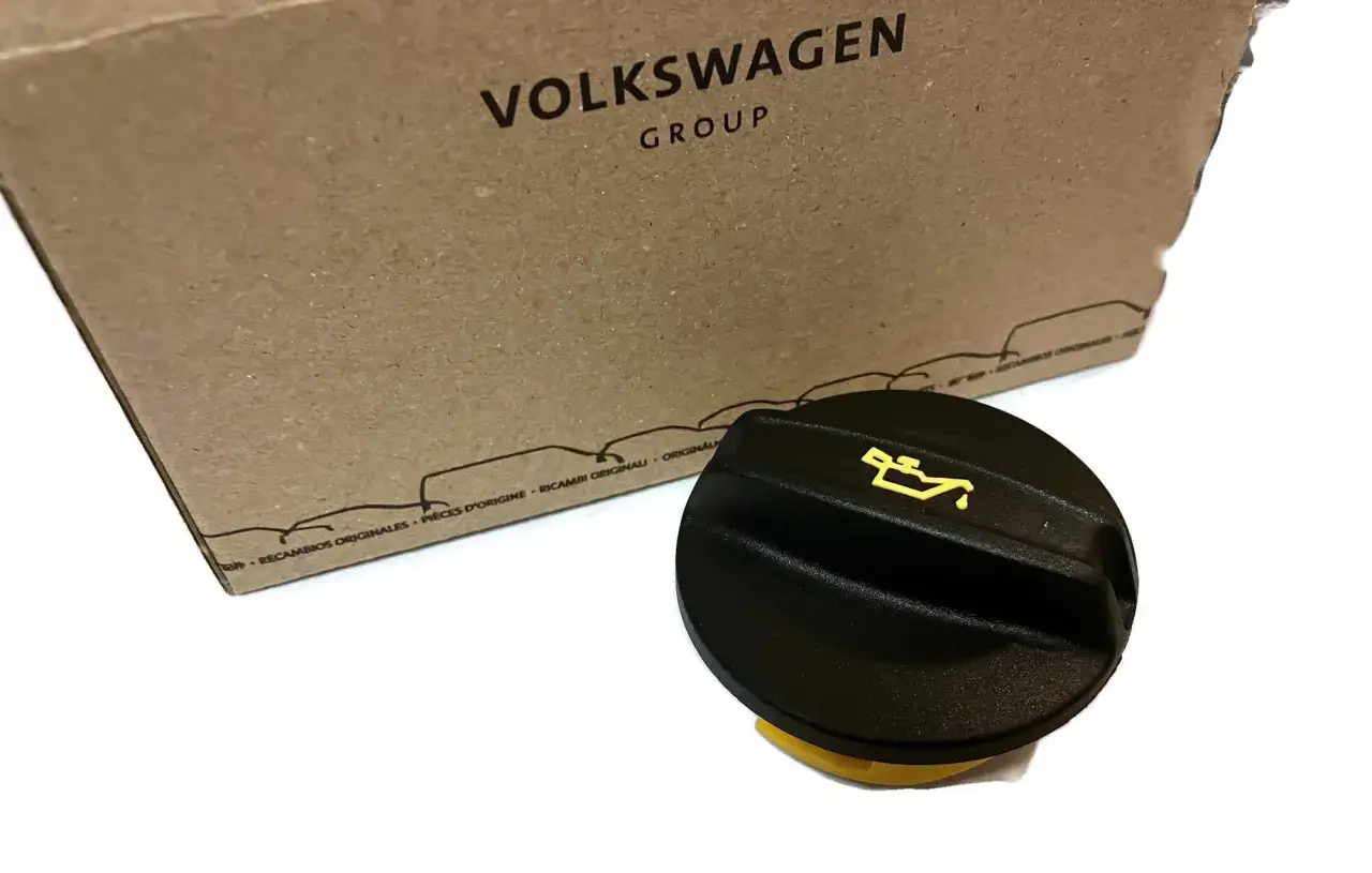 Czarny wlew oleju silnikowego Volkswagen Group z żółtym symbolem.