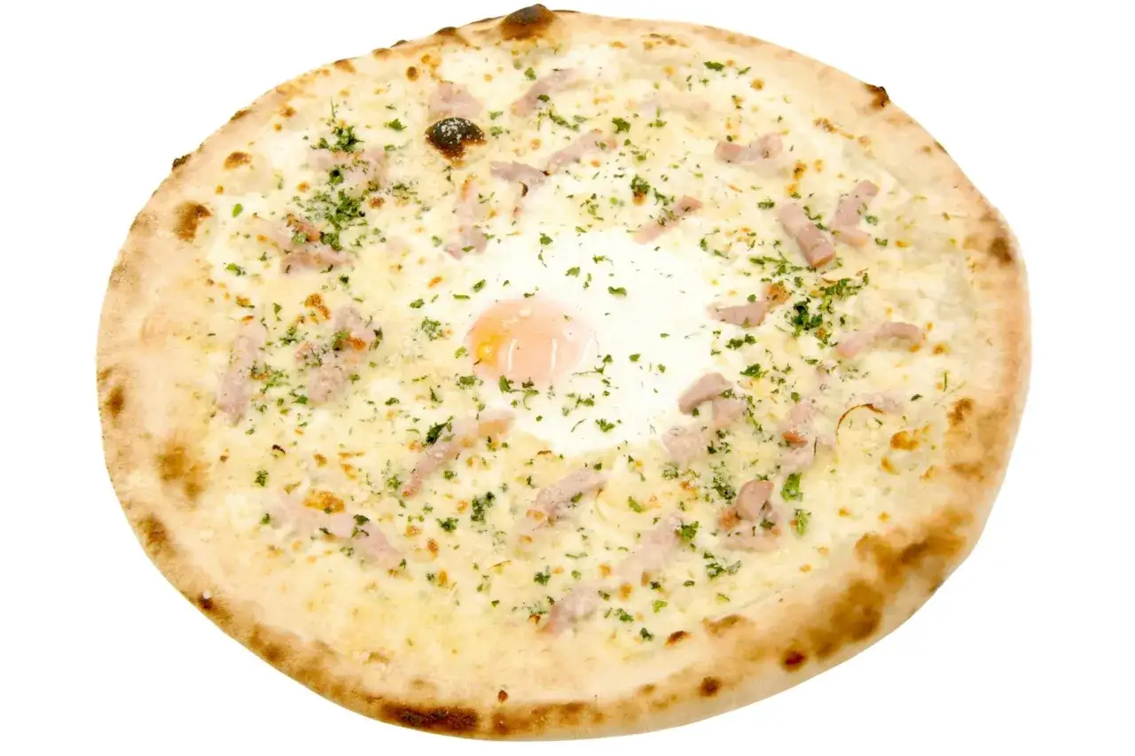 Pizza carbonara z jajkiem sadzonym pośrodku, kawałkami boczku i posypana natką pietruszki.