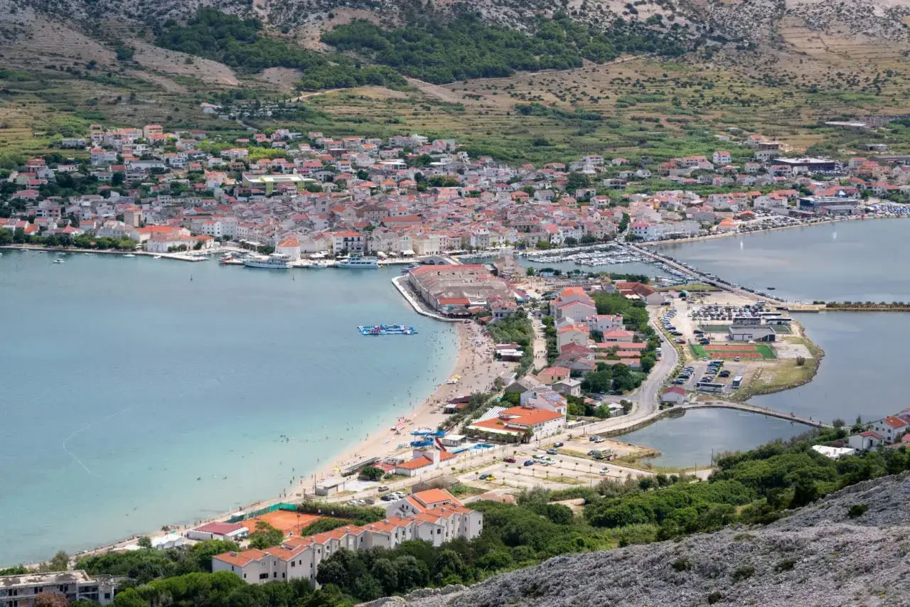 Widok na chorwackie miasteczko z zatoką, plażą i górami. Ciekawe ciekawostki o Chorwacji czekają na odkrycie!