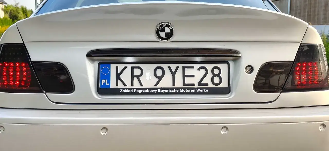 Srebrne BMW z przyciemnionymi lampami i tablicą rejestracyjną KR 9YE28.