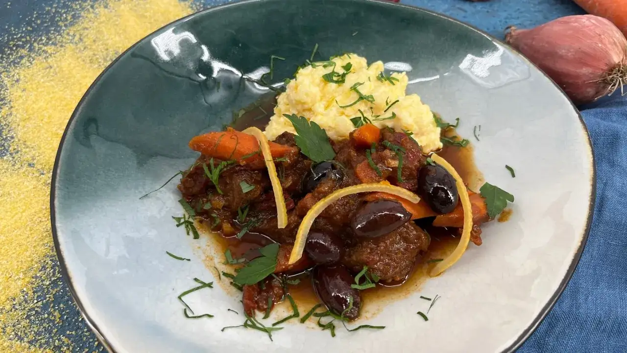 Herzhaftes Stracotto di manzo mit cremiger Polenta, Oliven und Karotten. Ein Genuss für Feinschmecker.