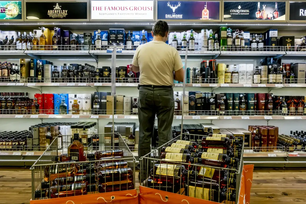 W sklepie wolnocłowym na lotnisku można kupić alkohol. Widać tu bogaty wyb&oacute;r whisky i innych alkoholi.
