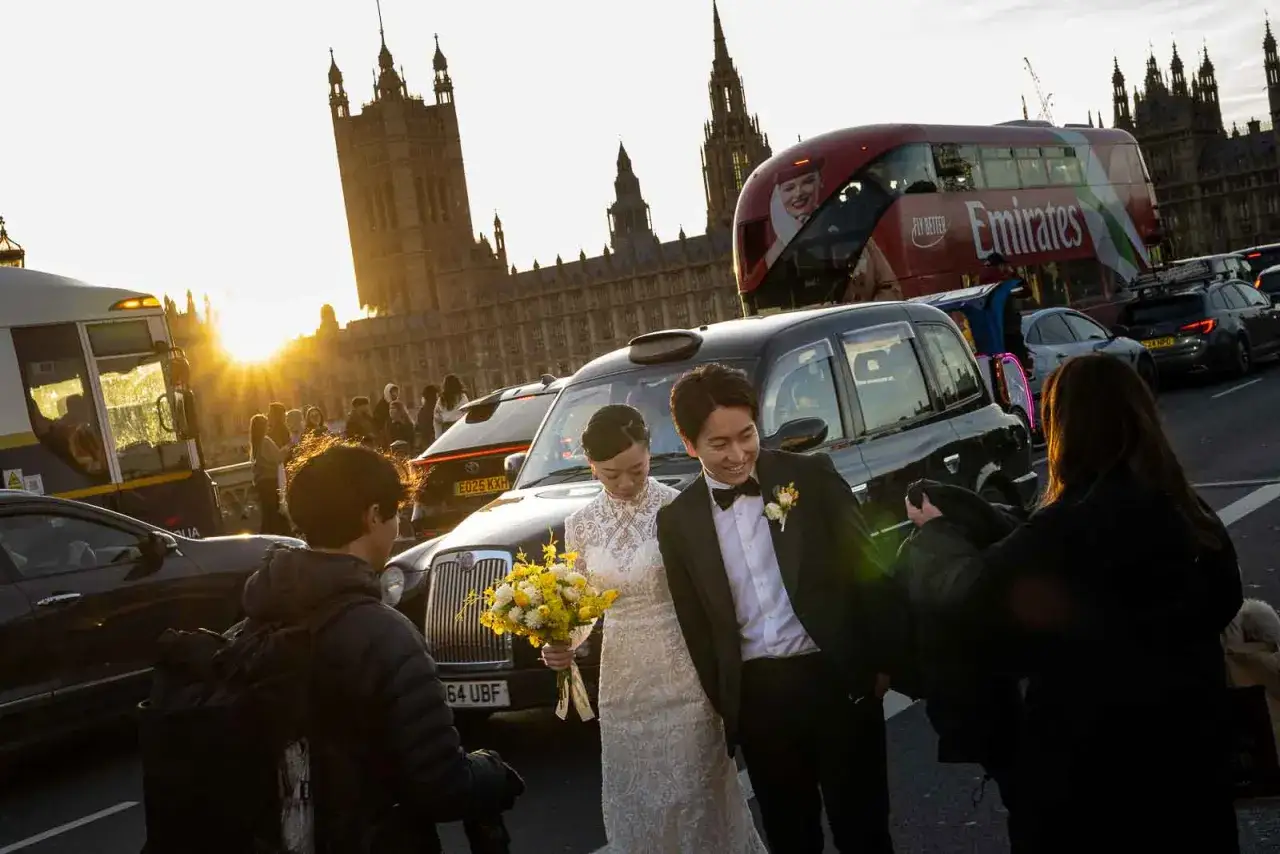 Ślubna sesja w Londynie. Różne rodzaje fotografii uchwyciły parę młodą na tle Big Bena i czerwonego autobusu.