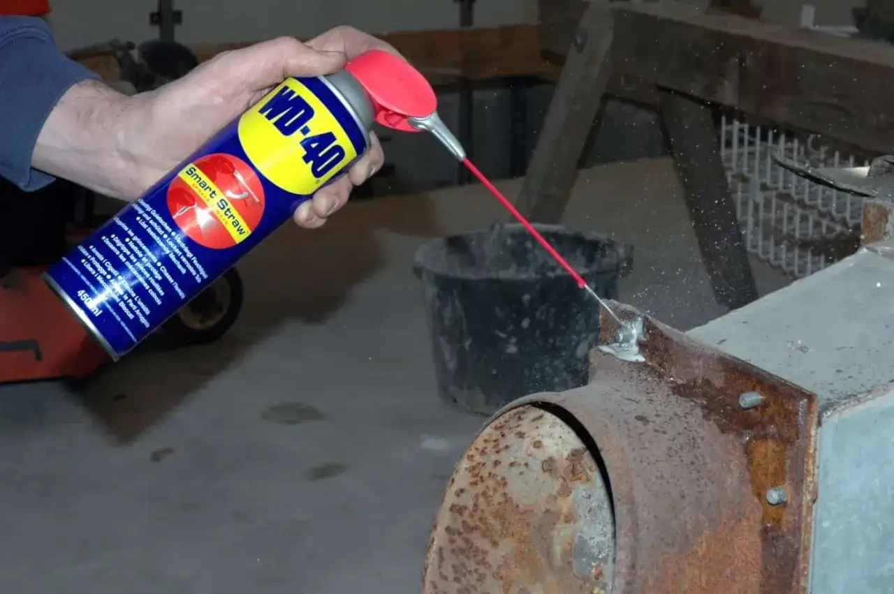 WD-40 wird auf ein rostiges Metallteil gespr&uuml;ht, um **Rost von Edelstahl entfernen** zu helfen.