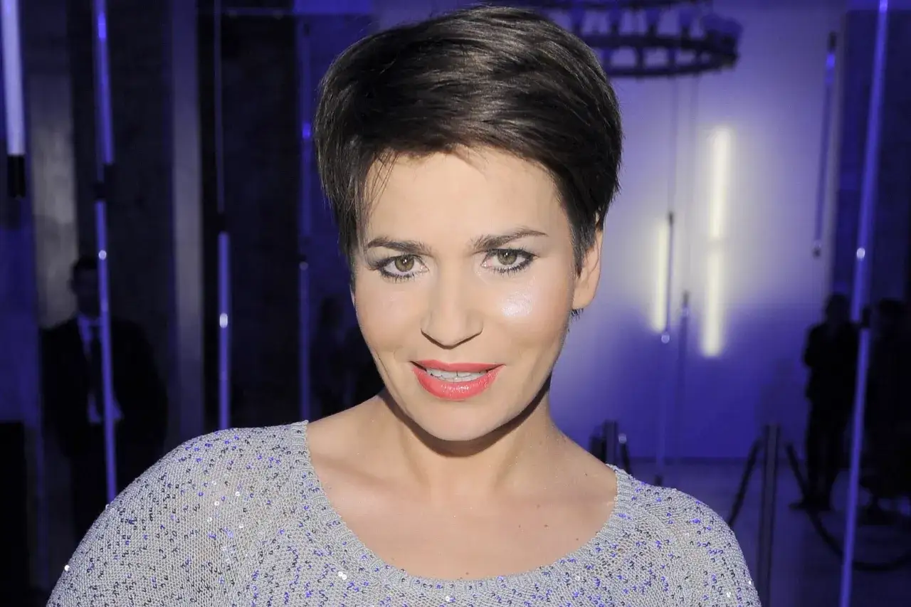 Dorota Deląg w błyszczącej kreacji, uśmiechnięta. Czyżby myślała o swoim mężu?