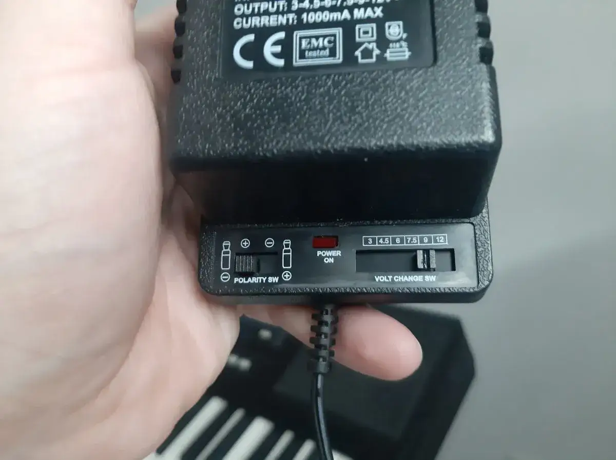 Przełącznik polaryzacji na zasilaczu pokazuje, który kabel to plus. Symbol 