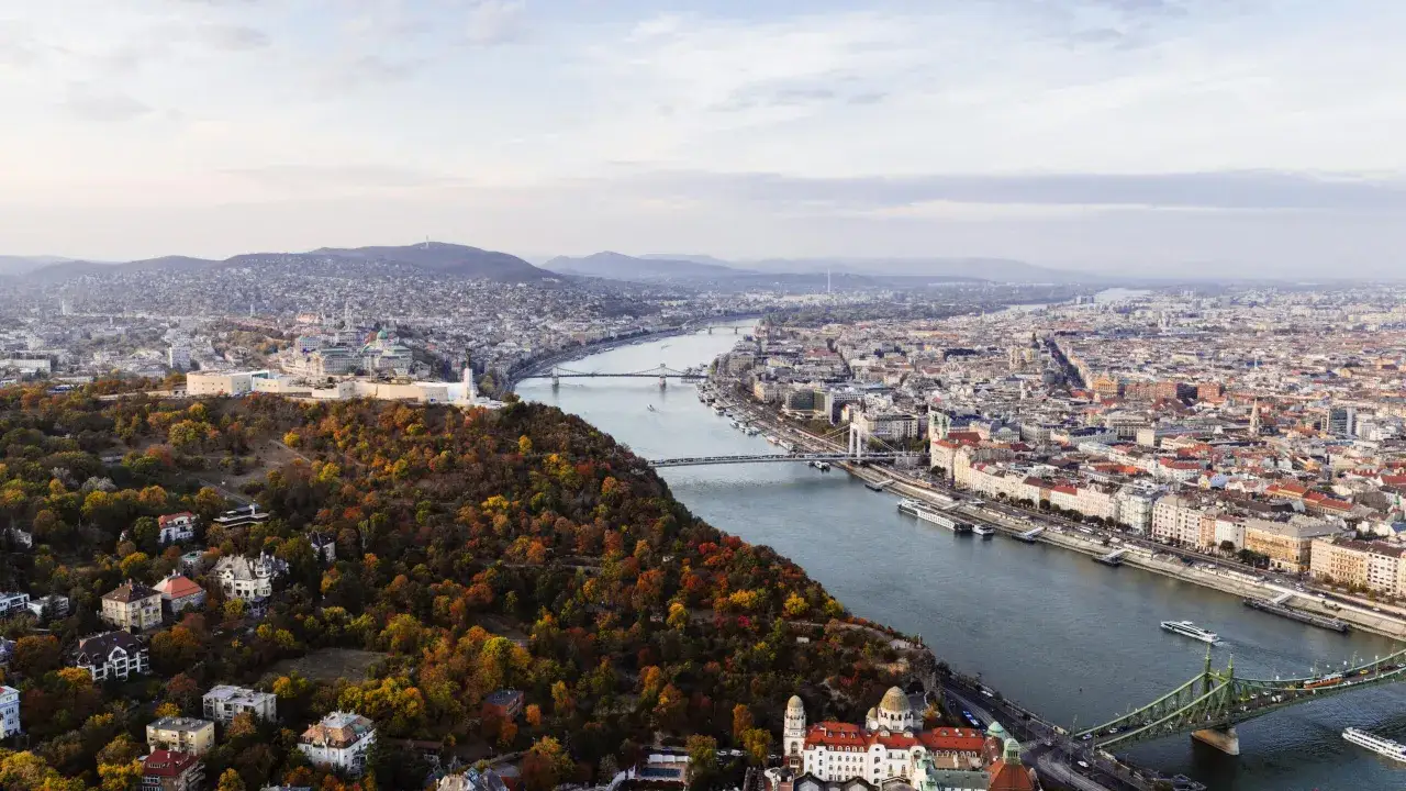 Budapeszt jesienią, z widokiem na Dunaj i mosty. Warto sprawdzić ceny na Węgrzech przed podróżą.