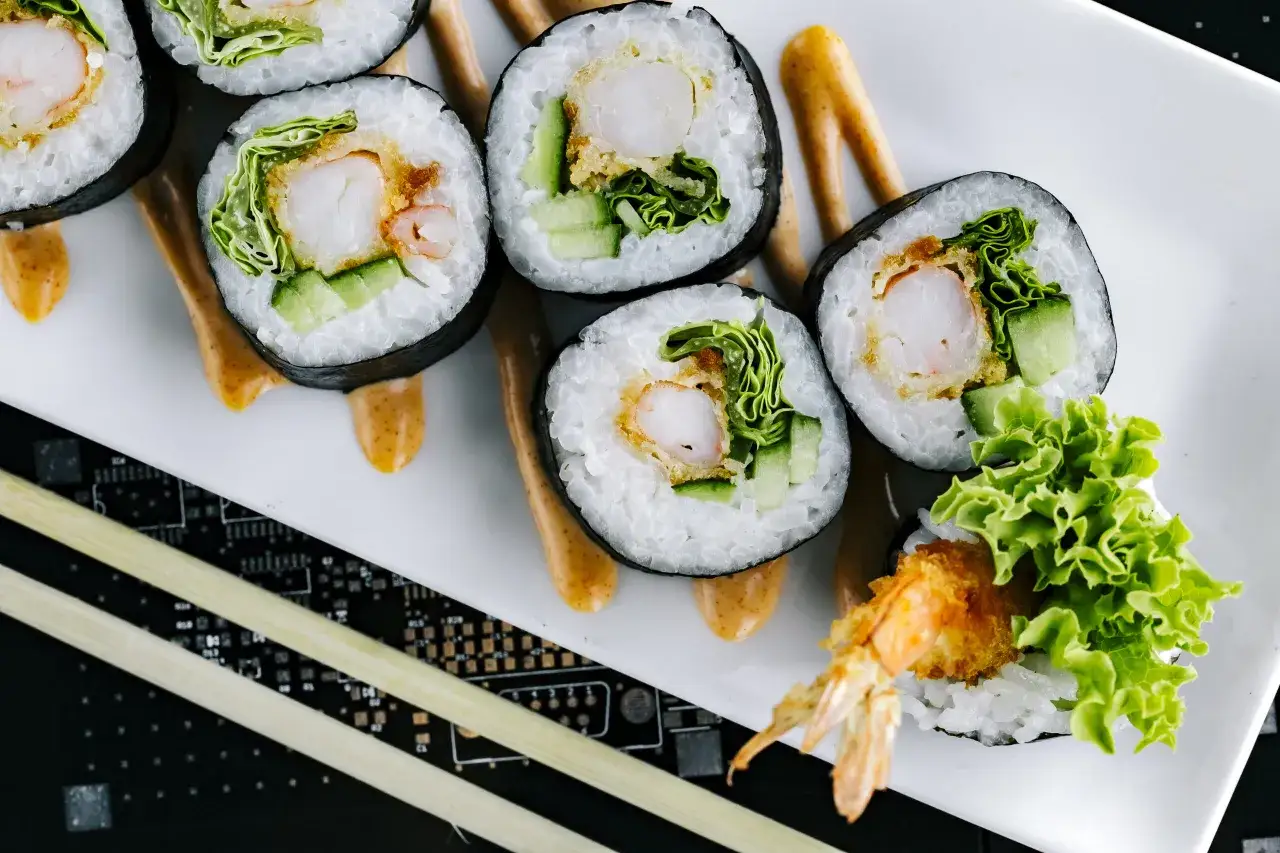 Futomaki co to? Rolka sushi z krewetką w tempurze, ogórkiem i sałatą, polana pikantnym majonezem.