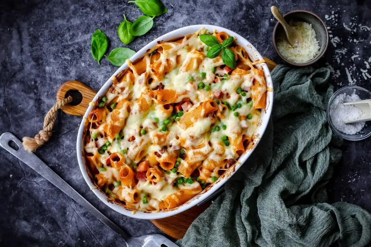 Herzhaftes Rigatoni al Forno mit Erbsen und Schinken, überbacken mit geschmolzenem Käse. Ein Genuss!