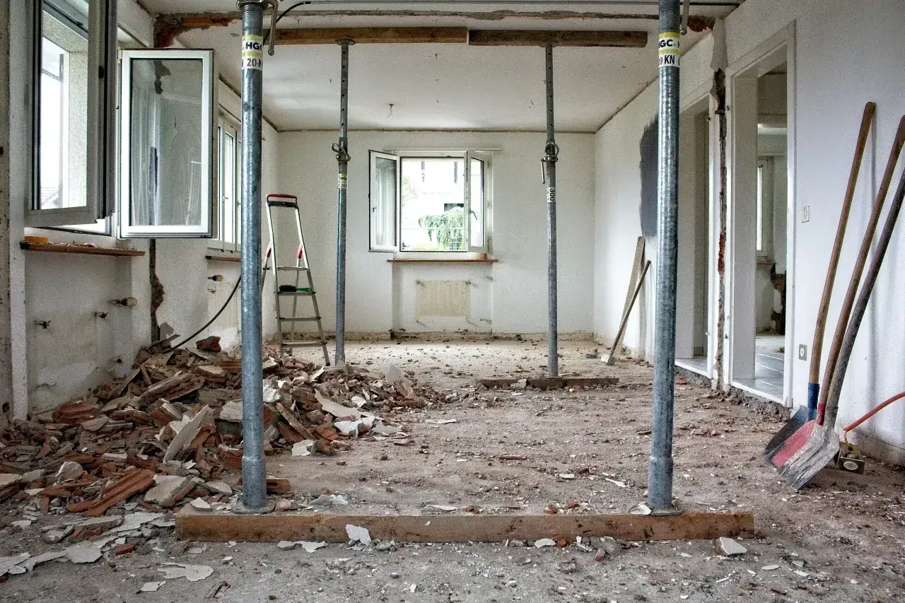 Remont starego domu: jak rozpoznać ścianę nośną? Widok wnętrza po wyburzeniach, z podporami stropowymi i gruzem.