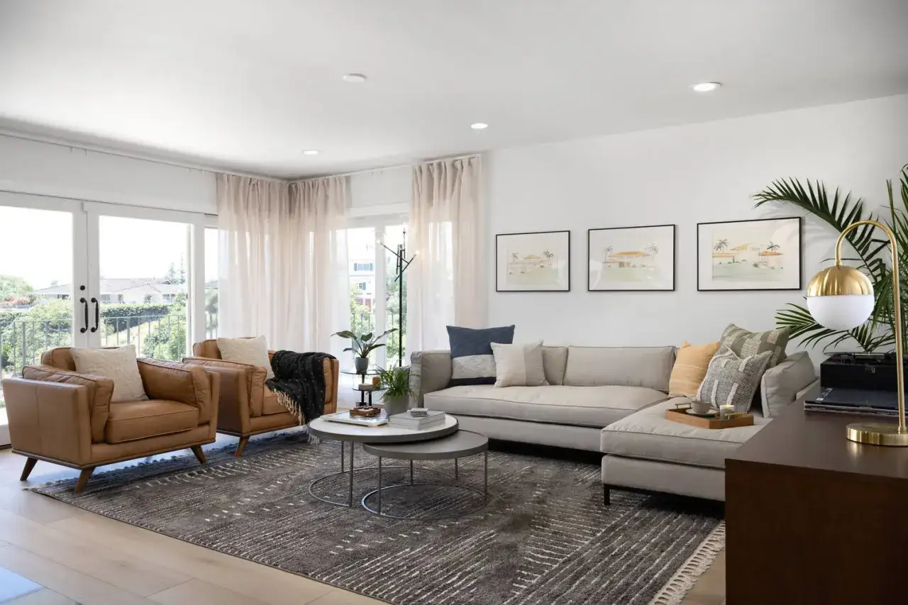 Gemütliches Wohnzimmer mit Ledersesseln, einem Ecksofa und Kunstwerken, die verschiedene Stilrichtungen vereinen.