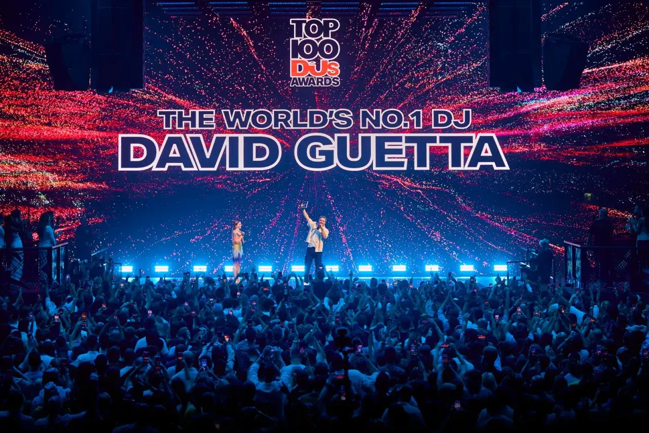 David Guetta, jeden z najbardziej znanych DJ-ów, odbiera nagrodę na scenie przed tłumem fanów.