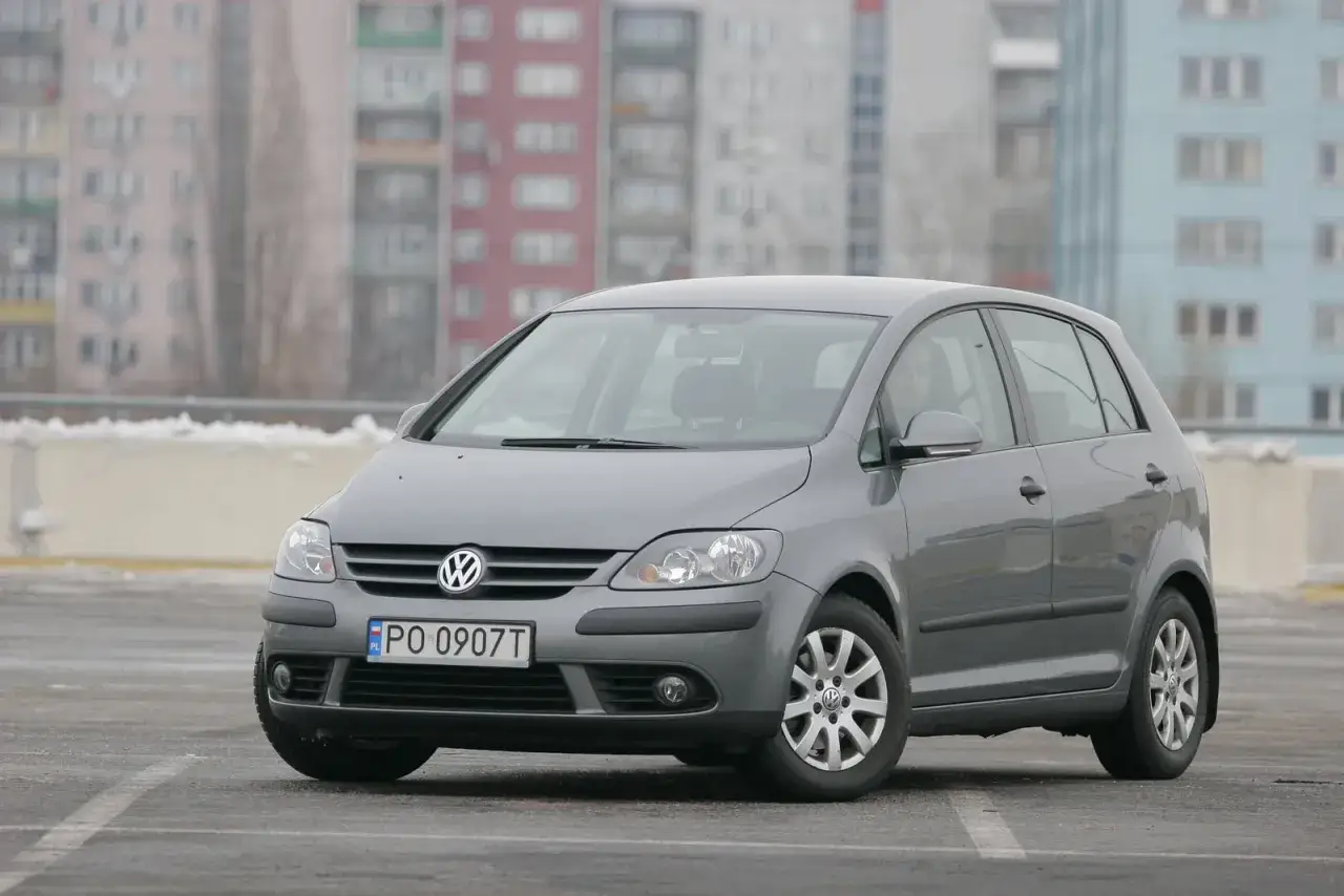 Szary Volkswagen Golf 5 Plus z przodu, gotowy do wymiany żarówki.