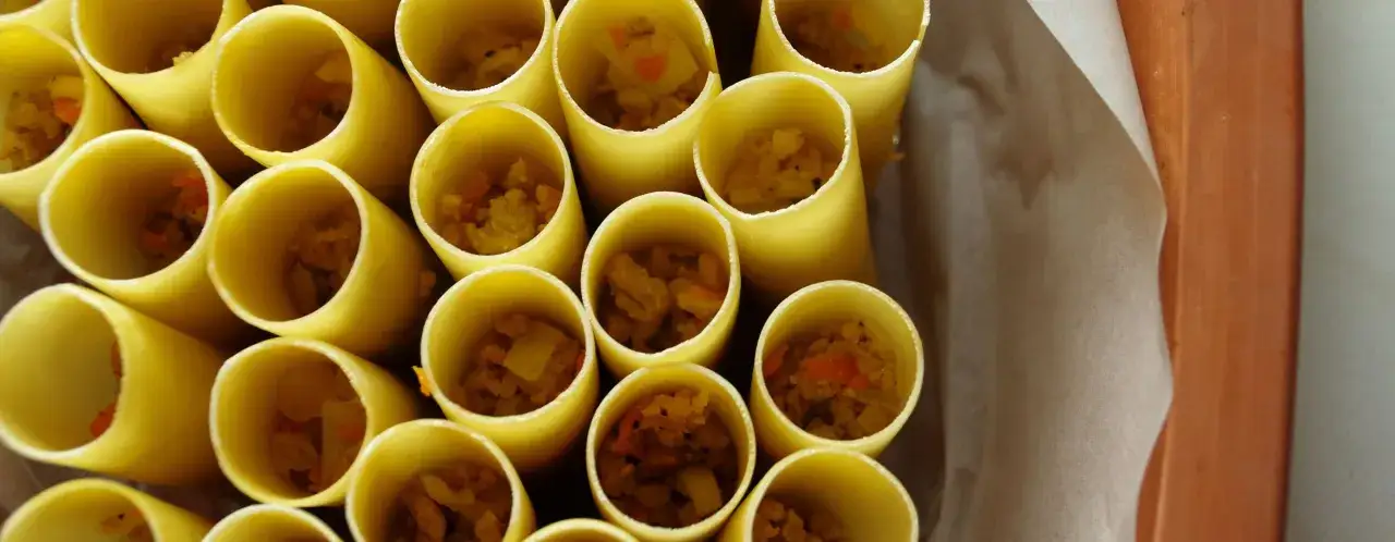 Przygotowane do pieczenia conchiglioni, wypełnione farszem warzywnym.