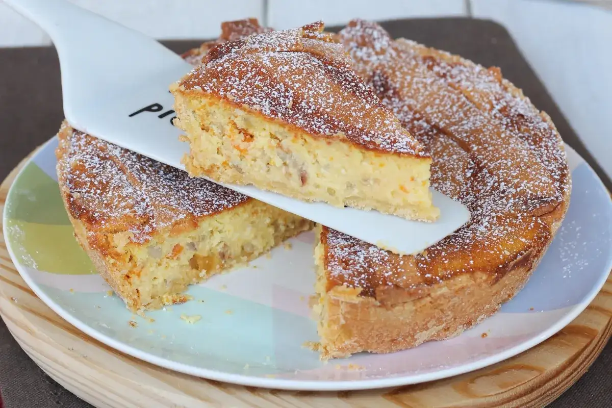 Una fetta di pastiera napoletana con pasta frolla, ripiena di grano cotto, ricotta e aromi, cosparsa di zucchero a velo.
