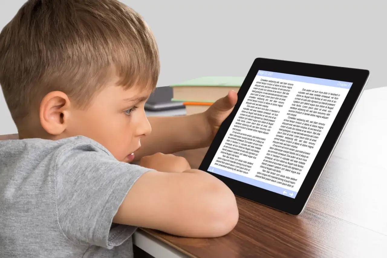 Niño concentrado en la comprensión lectora online en una tablet.