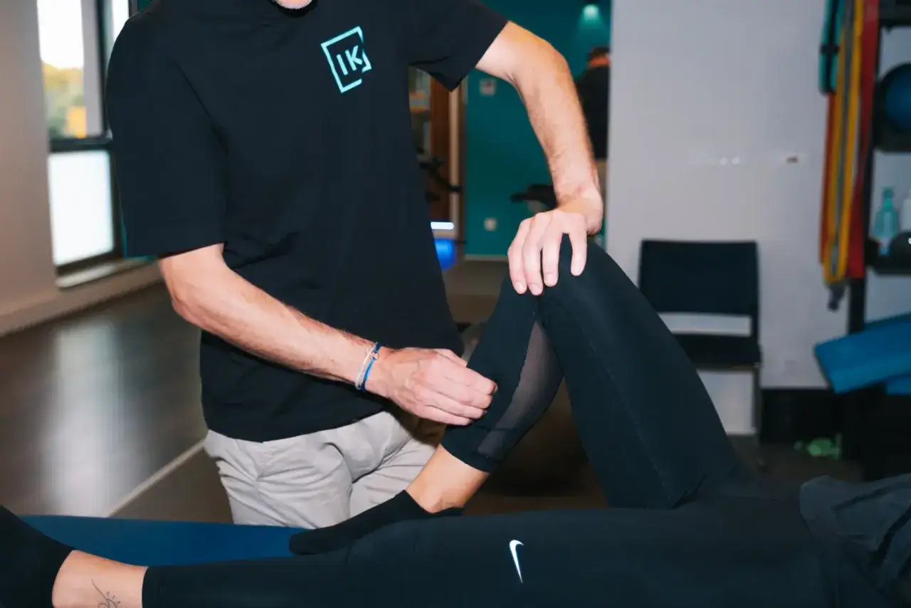 Un kin&eacute;sith&eacute;rapeute examine le genou d'une patiente, un geste cl&eacute; pour optimiser le taux de r&eacute;ussite de la proth&egrave;se du genou.