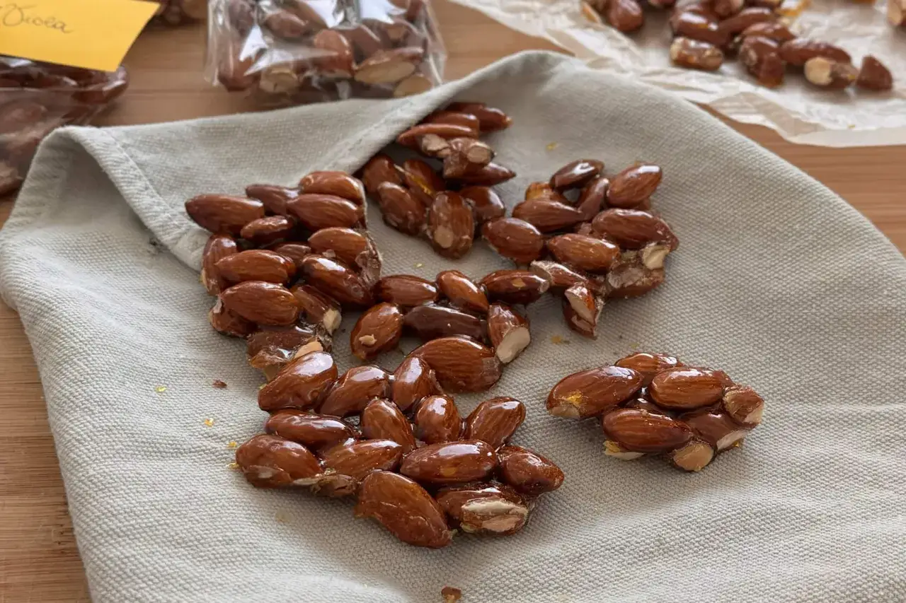 Croccante di mandorle lucide e dorate, un dolce invitante su un panno grigio.