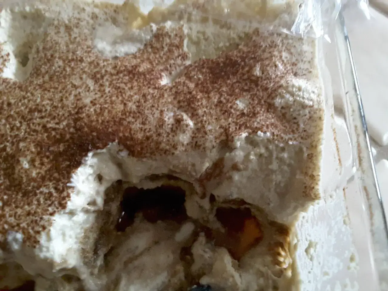 Tiramisu avec une crème au mascarpone trop liquide, saupoudré de cacao. La texture semble un peu fondue.