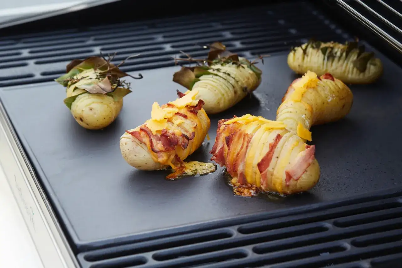 Pommes de terre Hasselback garnies de lard et de fromage, prêtes pour le barbecue. Quelle pomme de terre barbecue !