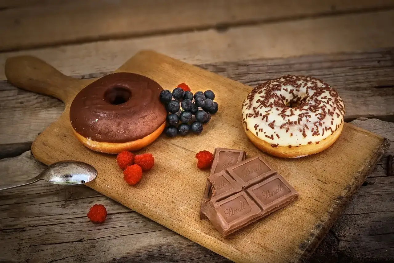 Słodka uczta: pączki, czekolada i owoce leśne na desce. Idealna pizza na słodko!
