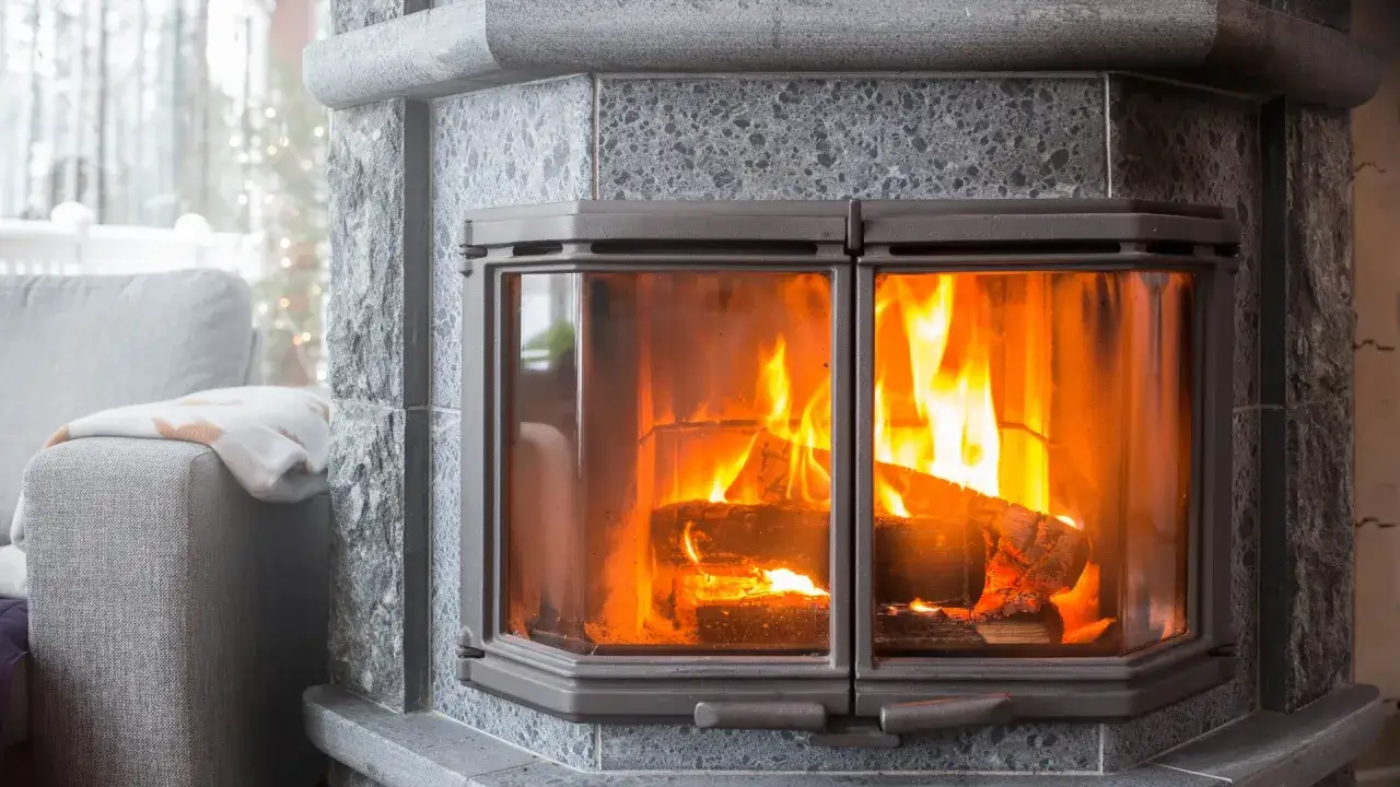 Ein gemütliches Feuer brennt in einem Kamin aus Speckstein. Was ist Speckstein? Ein natürlicher Stein, der Wärme speichert und abgibt.