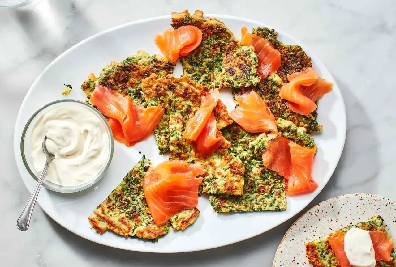 Herzhafte Pfannkuchen mit Spinat und Lachs, serviert mit einem Klecks Sour Cream. Ein köstliches Gericht für jeden Anlass.