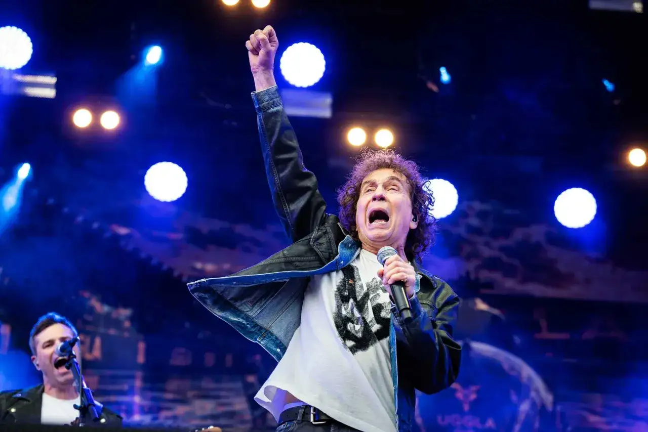 Magnus Uggla show Stockholm. Sångaren med uppsträckt näve och öppen mun, sjungandes med energi på scenen.