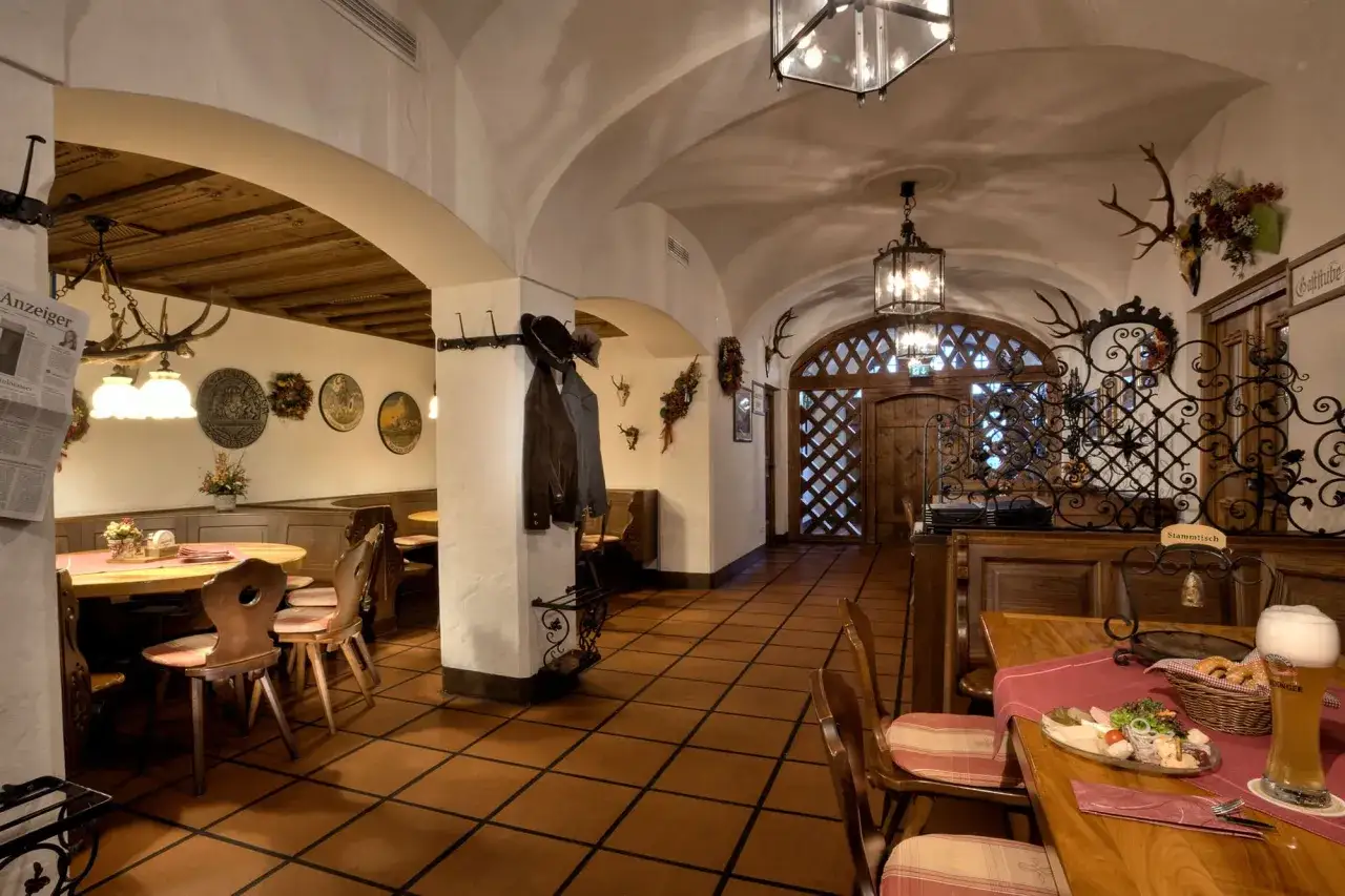 Gem&uuml;tliches Interieur eines Erdinger Brauhaus mit Holztischen, Jagdtroph&auml;en und traditioneller Dekoration.
