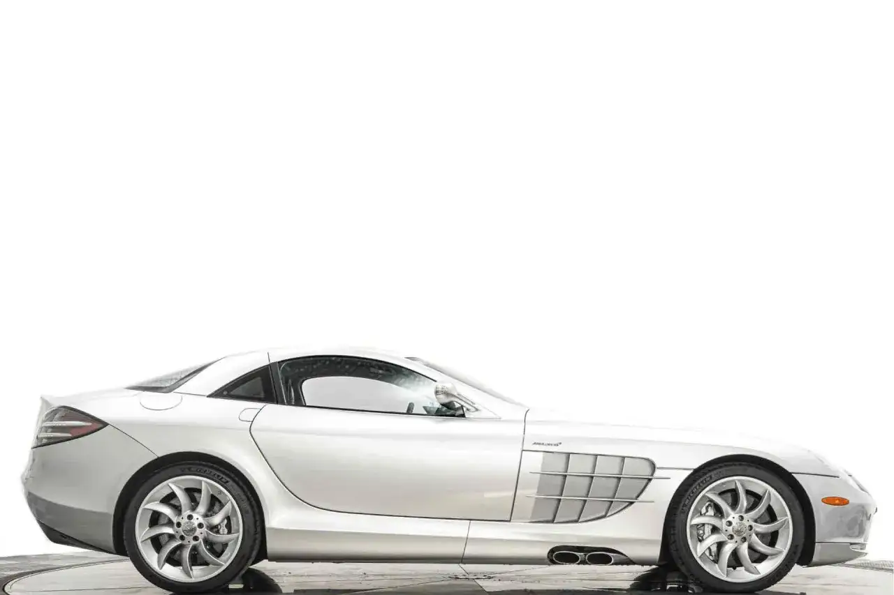 Srebrny Mercedes SLR McLaren, ikona motoryzacji, błyszczy na białym tle.