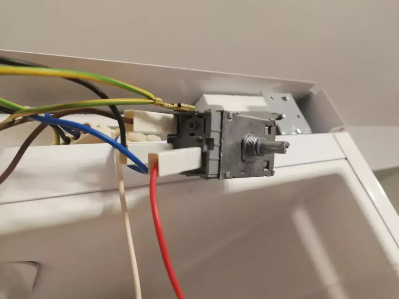 Termostat lodówki, który mógł spowodować, że lodówka nie chłodzi. Widać przewody i mechanizm regulacji.