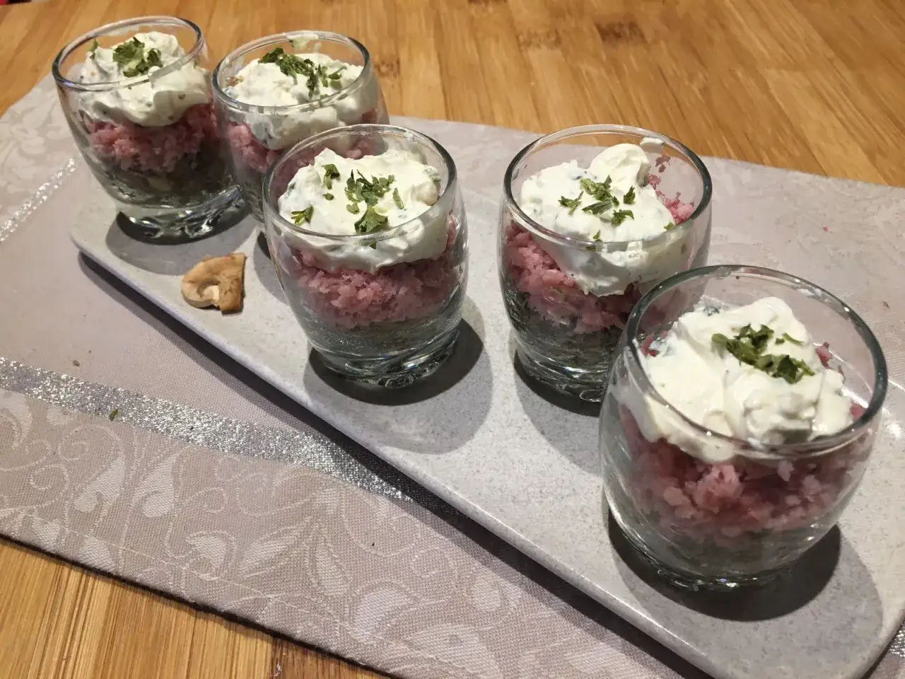 Petits verres de **champignons &agrave; la grecque** avec une garniture cr&eacute;meuse et des herbes fra&icirc;ches.