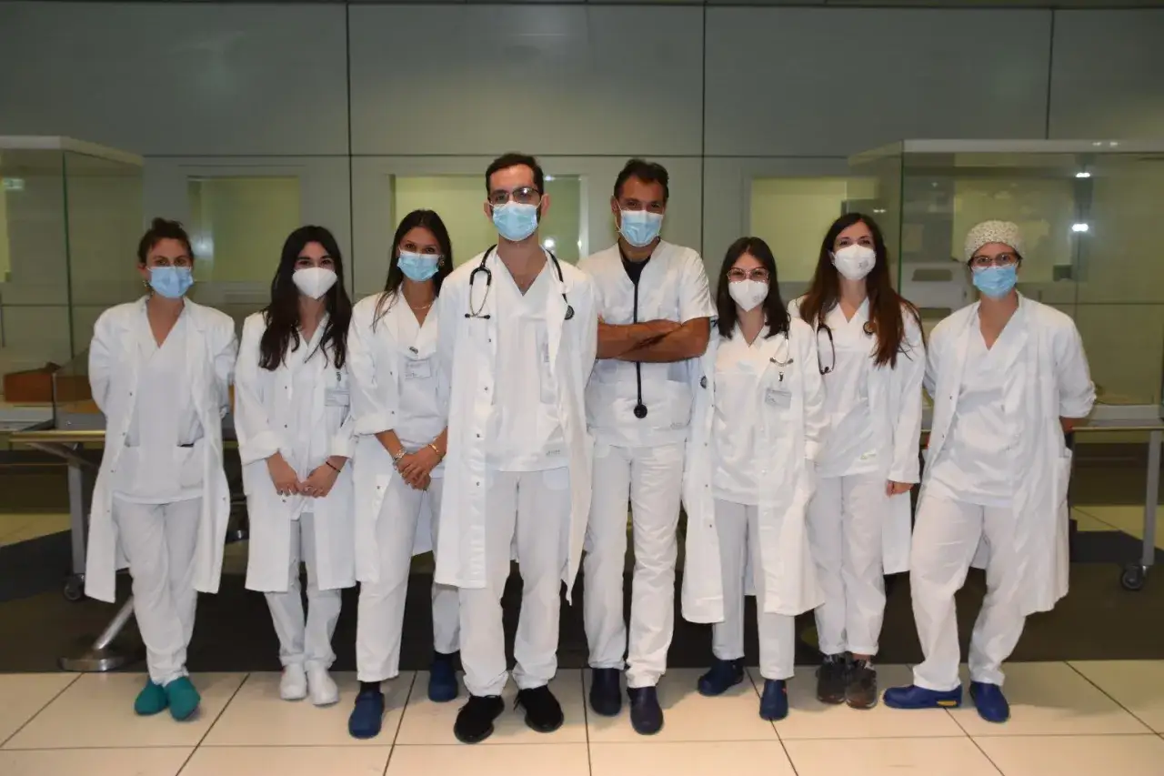 Un gruppo di medici in camice bianco, alcuni con stetoscopio, pronti per le loro specializzazioni dopo medicina.