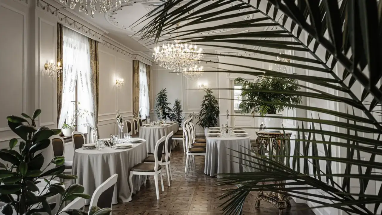 Elegancka brasserie z kryształowymi żyrandolami, białymi obrusami i roślinami. Idealne miejsce na romantyczną kolację.