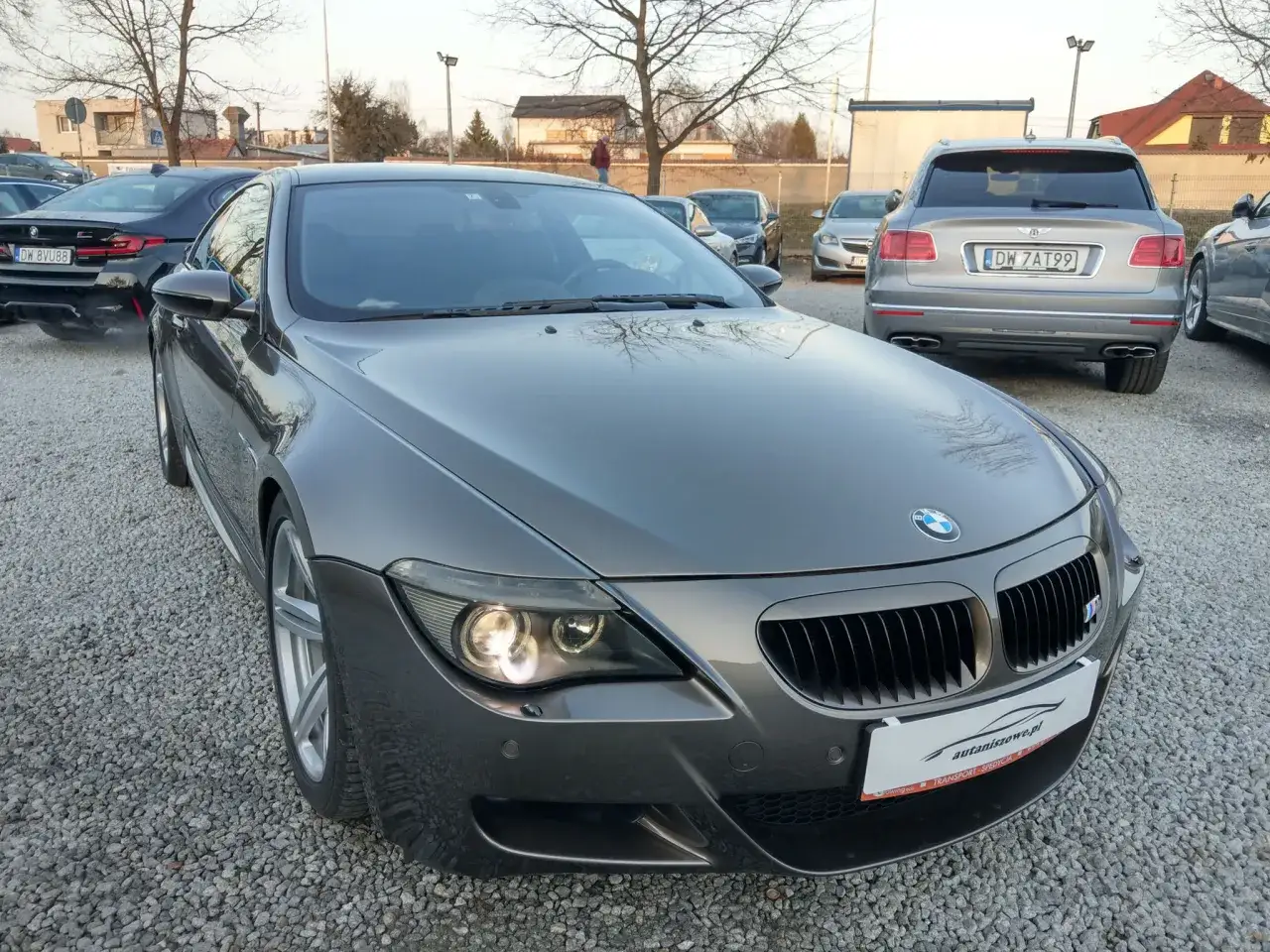 Szare bmw e63 na parkingu, obok inne samochody.