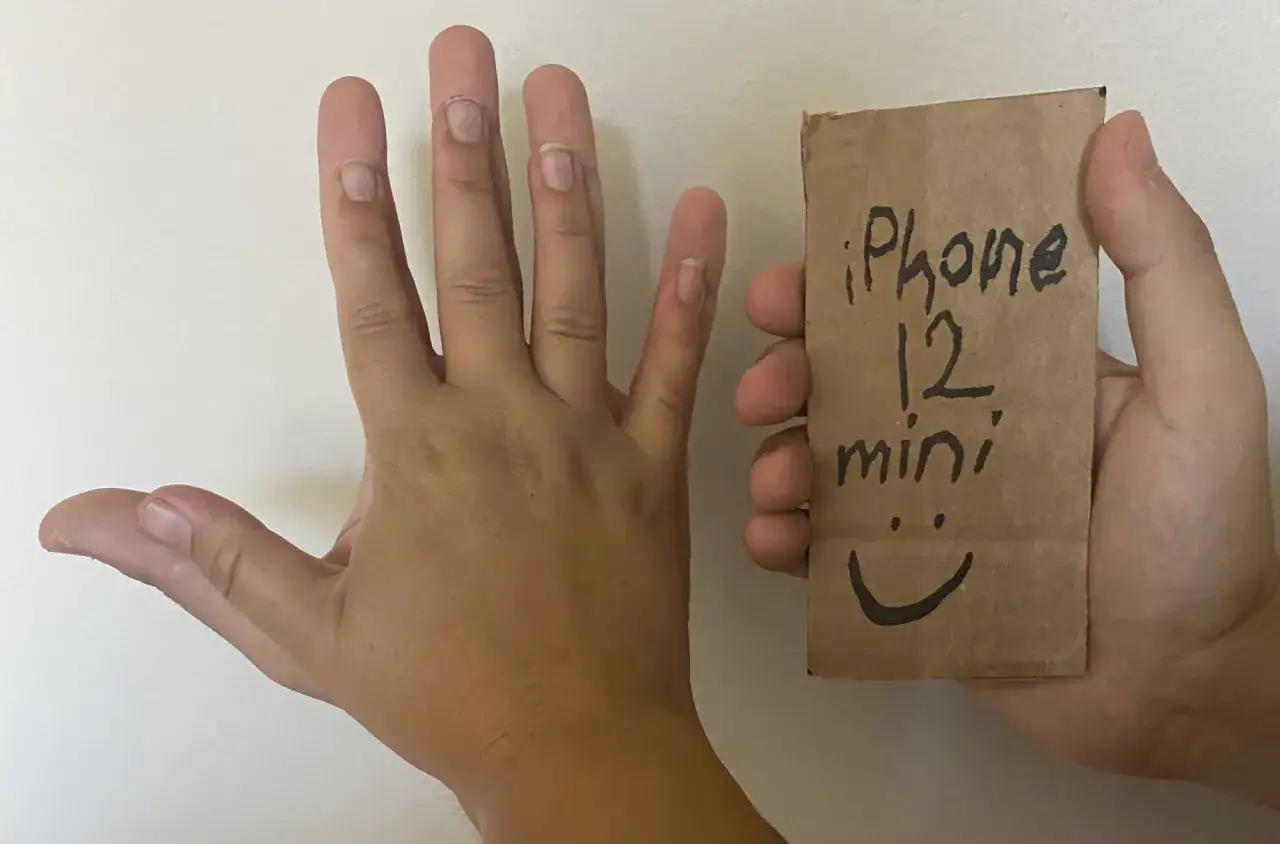 Main gauche ouverte, main droite tenant un petit sac en papier avec &eacute;crit 
