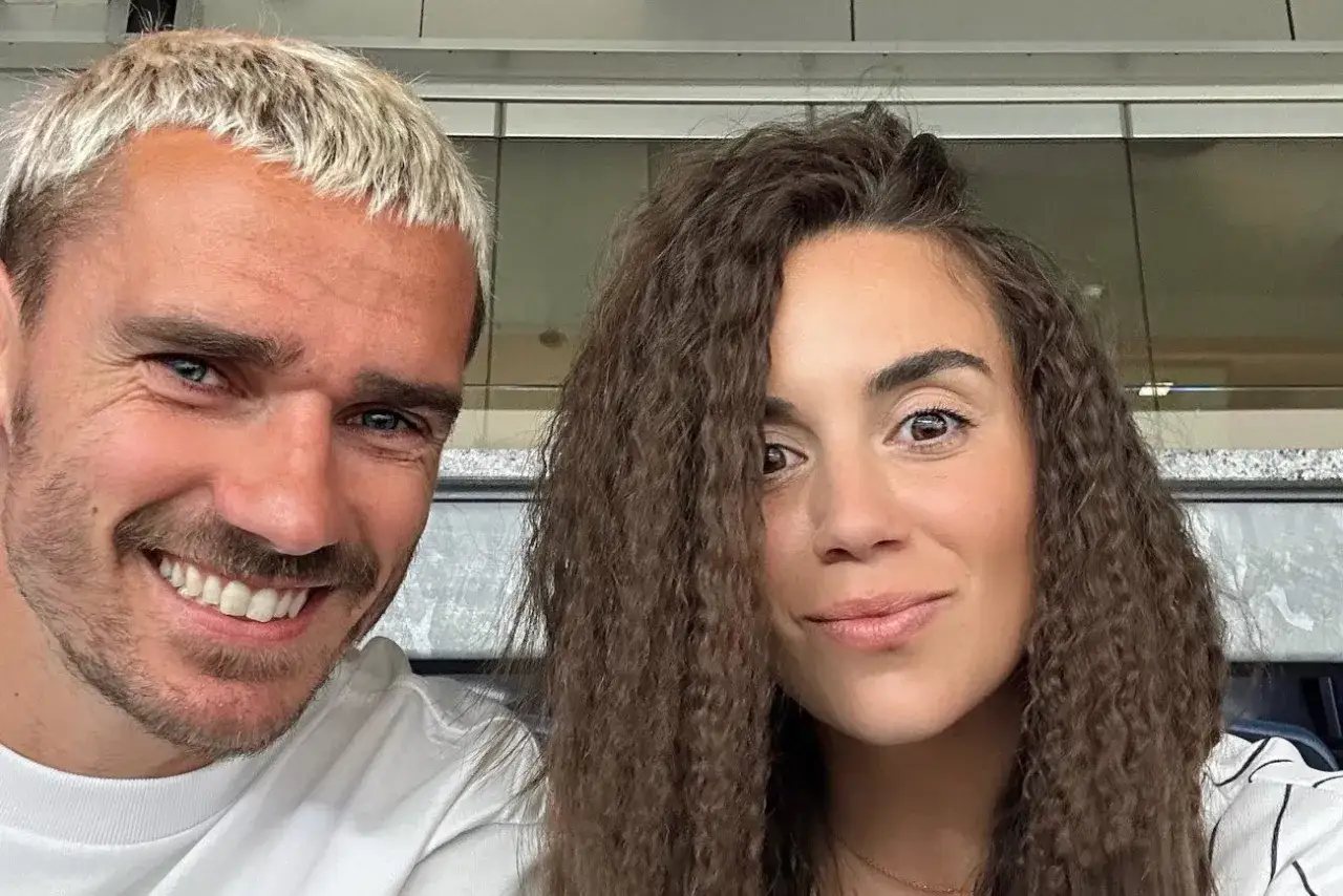 Antoine Griezmann, znany ze swojego francuskiego pochodzenia, uśmiecha się do zdjęcia z kobietą o kręconych włosach.