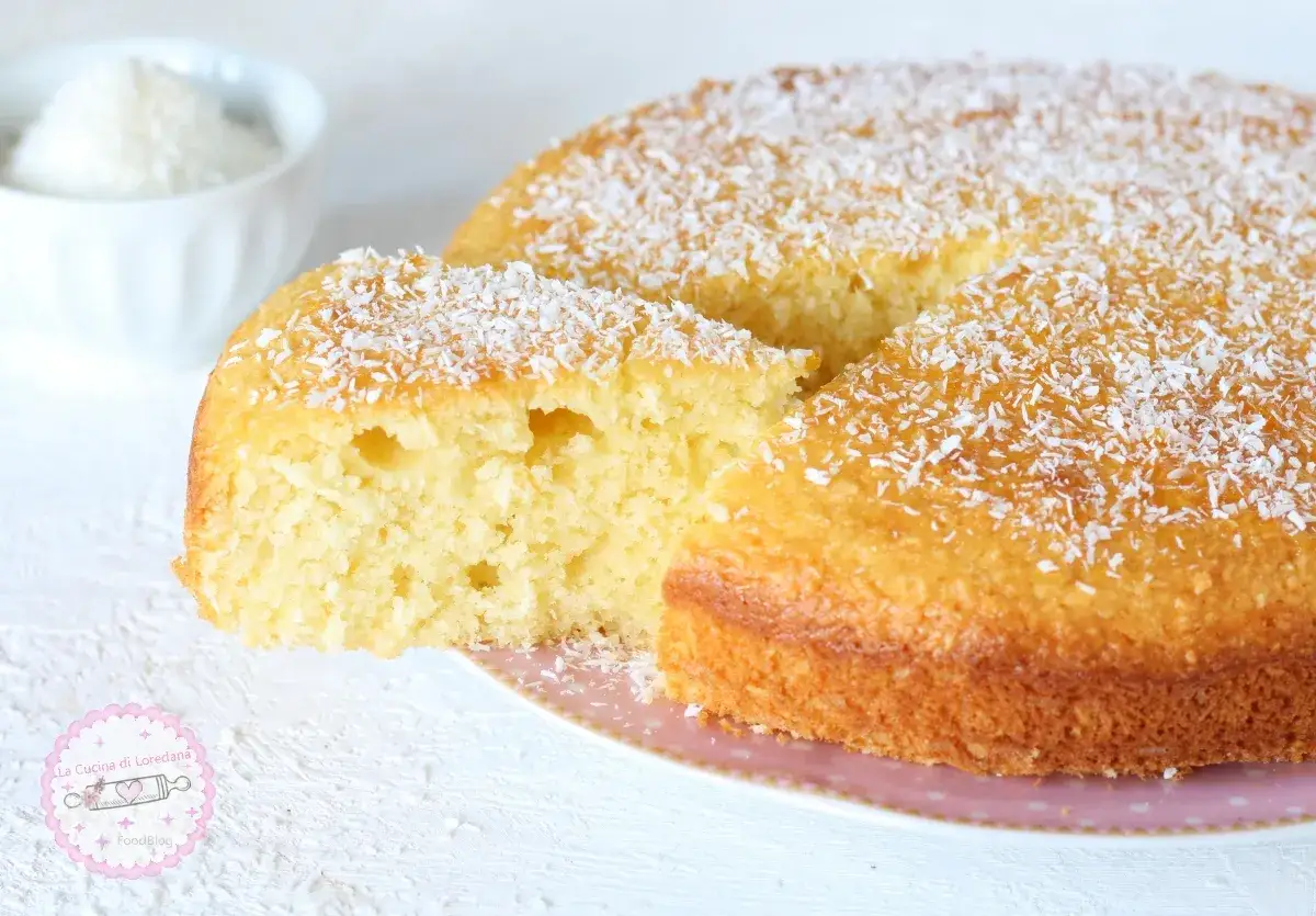 Torta soffice con farina di cocco, cosparsa di scaglie bianche, invitante e profumata.