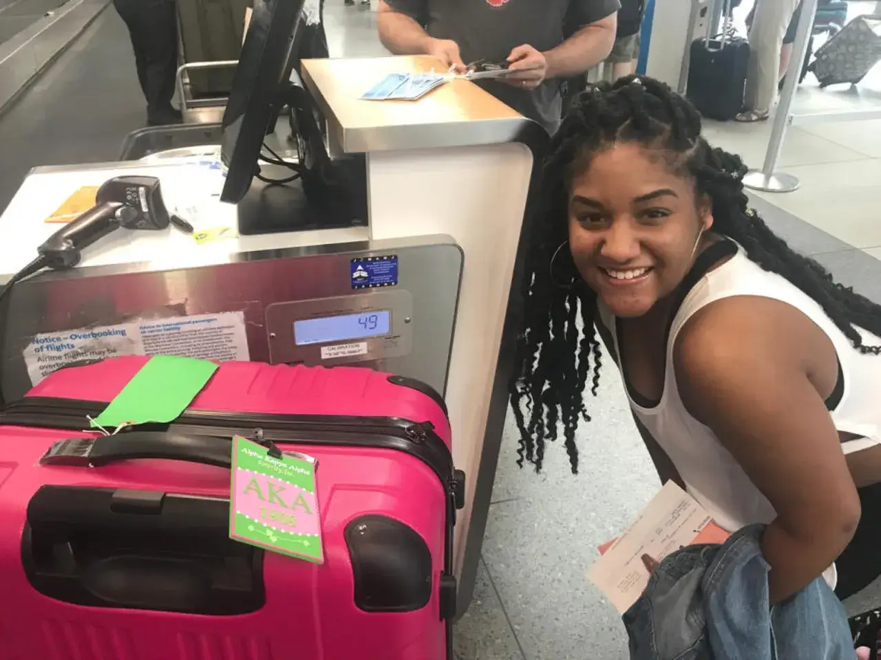 Junge Frau am Flughafen mit pinkem Koffer, bereit f&uuml;r ihr Gap Year.