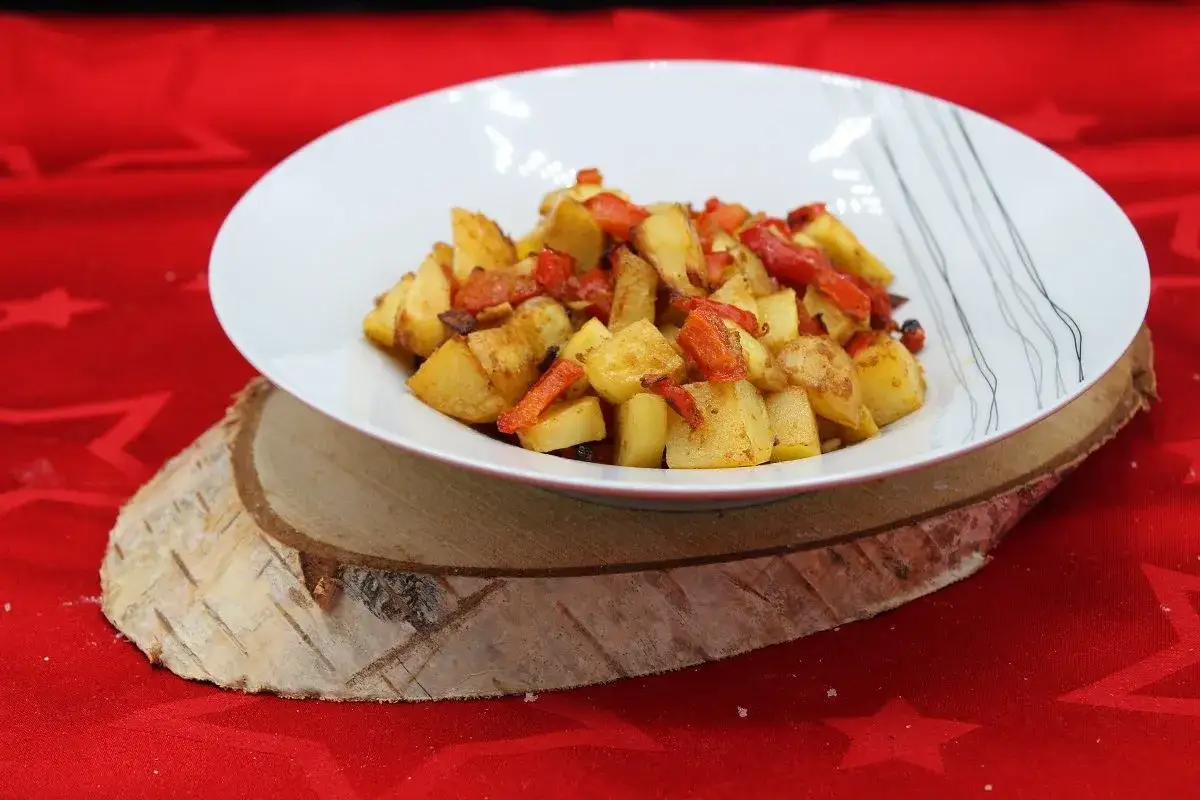 Un plat de pommes de terre et poivrons rouges rôtis, parfait pour une recette simple et savoureuse.