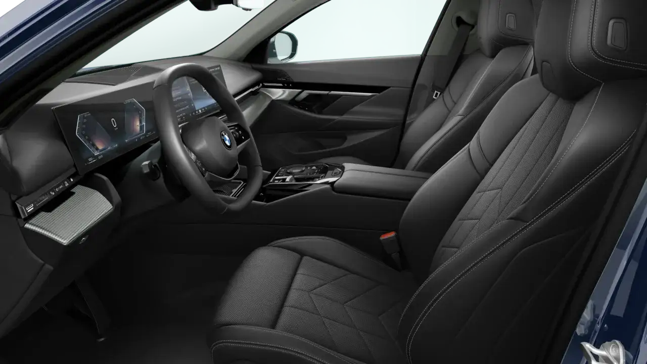 Wnętrze BMW 520 z czarną, skórzaną tapicerką i nowoczesnym panelem cyfrowym.