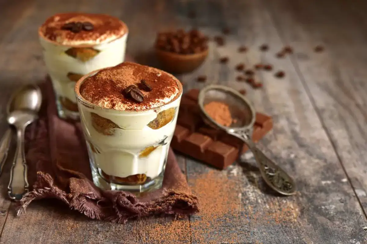 Delizioso tiramis&ugrave; con ricotta, strati di savoiardi e crema al caff&egrave;, spolverato di cacao e chicchi di caff&egrave;.